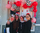 This image shows a group of women smiling outside a Dutch Bros location decorated with red balloons