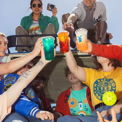 A group of Dutch Bros customers unite in a cheers with their drinks